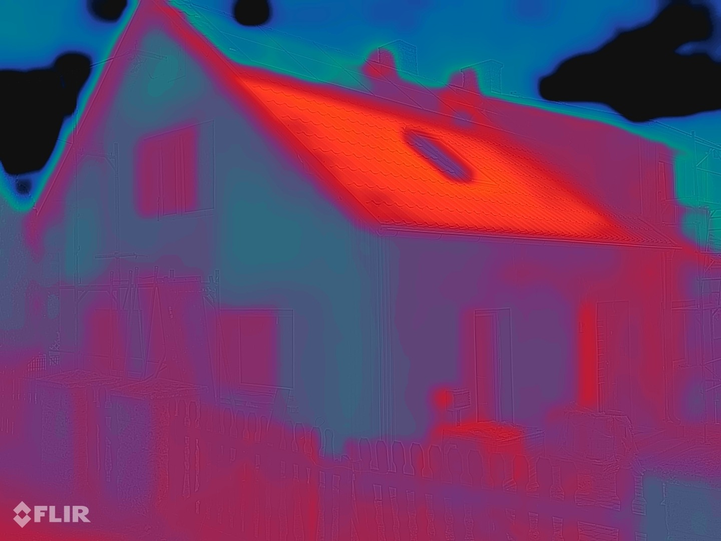 FLIR-varmebilde av samme fasade etter beleggingen: veggflaten blågrønn til fiolett